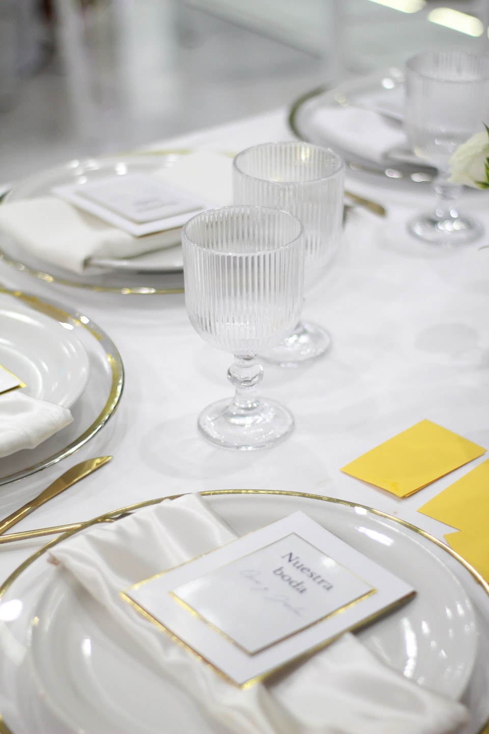 Elegante mesa decorada con acentos dorados para una celebración de boda.